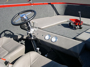 A quirky picture of a red kids wagon that is as big as a car and has a motor.