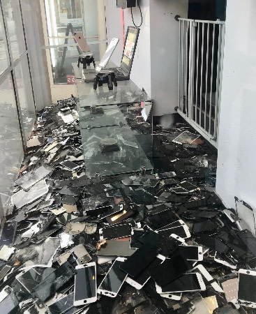 a heap of old phones in a storefront window. Maybe they should be recycled?